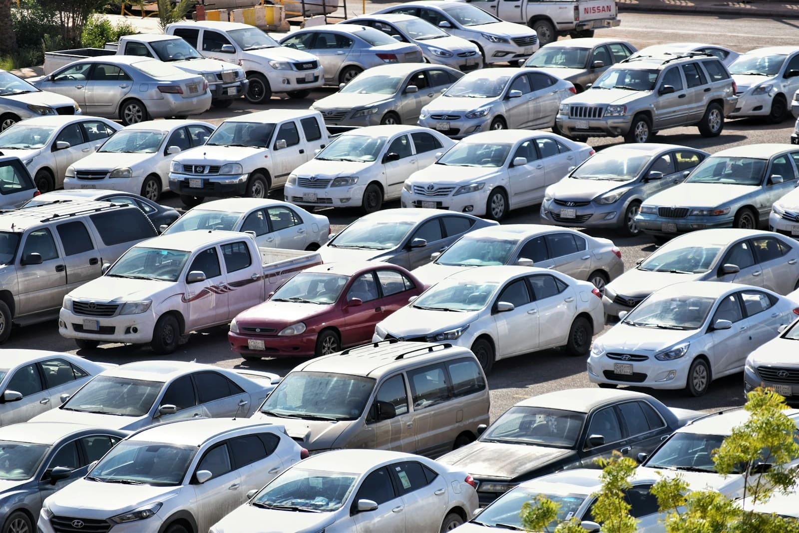 Crowded parking lot with many cars of different colors and models packed closely together in rows